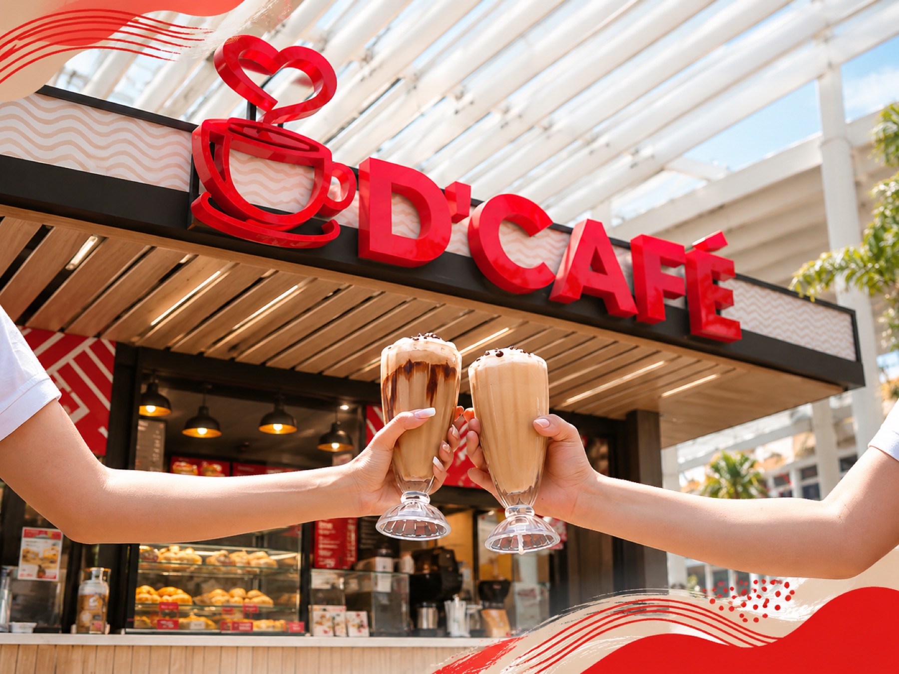 Brindis con dos bebidas frente a una tienda D'Café